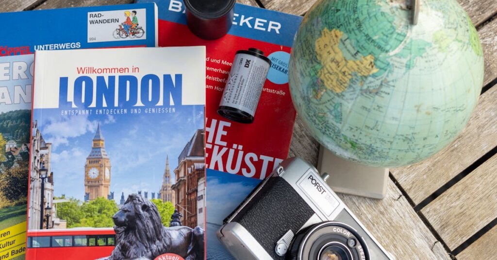 Flat lay featuring London travel guide, vintage camera, and globe, ideal for travel theme.